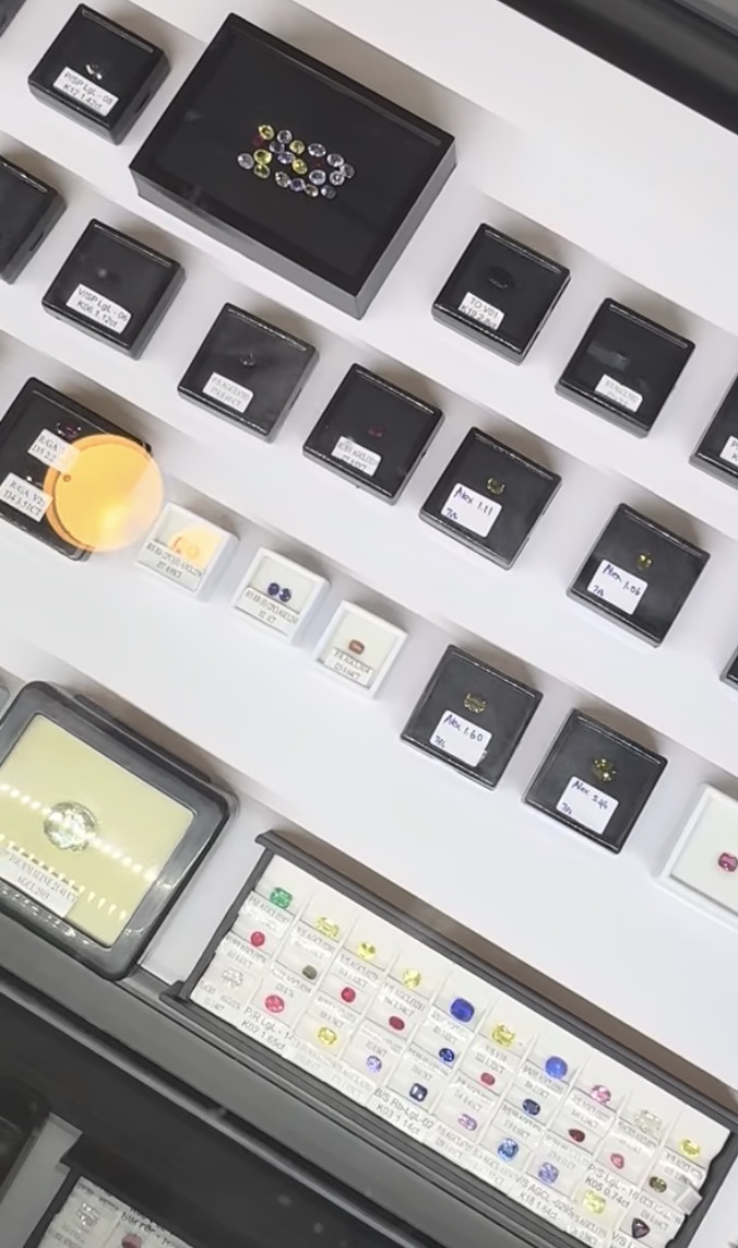 Gemstones organised in professional sorting trays with a loupe