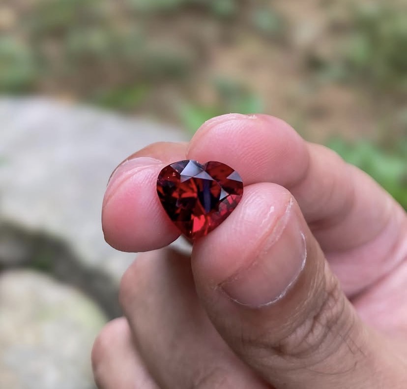 Heart-shaped red gemstone held in hand